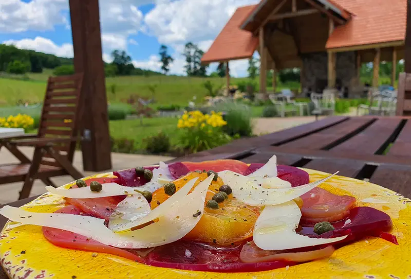 A garden carpaccio served outdoors, the wellness pavilion beyond