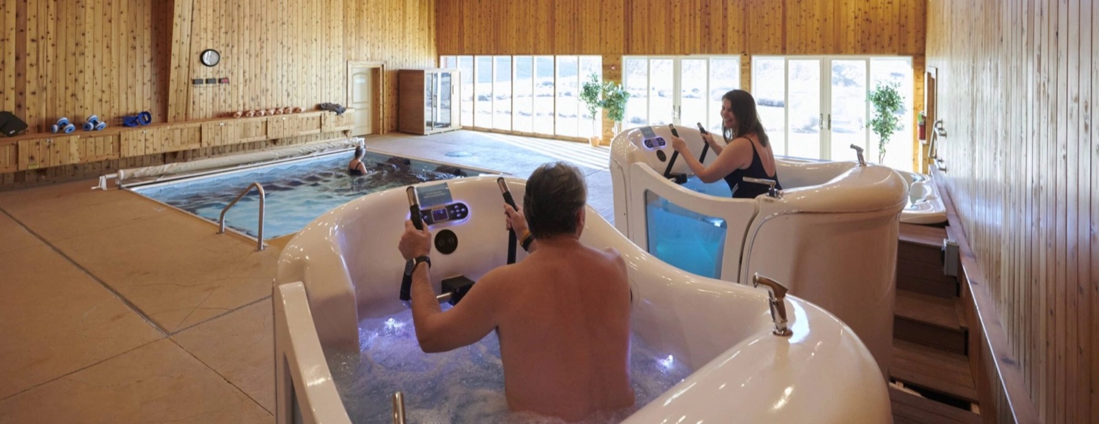 Guests riding hydro bikes beside the endless-stream pool